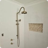 Chrome rain shower and handheld on white tiles, with a mosaic niche.